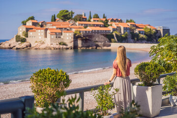 Woman tourist on background of beautiful view of the island of St. Stephen, Sveti Stefan on the...