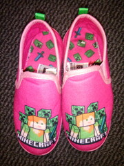 Fototapeta premium Kids pink minecraft slippers on a dark background. 06-04--2022, Lancashire, UK