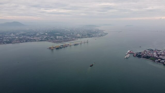 Aerial view panning right of ship vessel move at Penang sea. Background is Penang Bridge