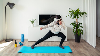 Man enjoying virtual reality glasses, Wushu student playing video game on room