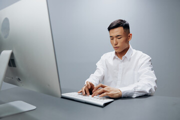 man in a white shirt works at a computer in the office isolated background