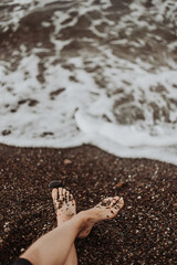 legs of a young woman by the sea, sea waves
