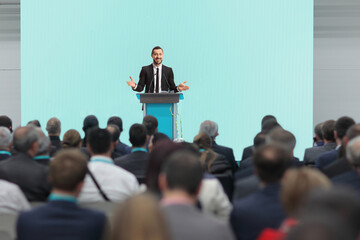 Business conference with audience and a speaker on podium