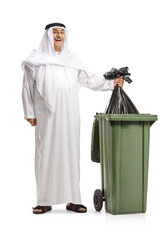 Full length portrait of a happy arab throwing a black plastic bag in a bin