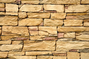 Part of the beige stone wall. Brown rock wall background texture.