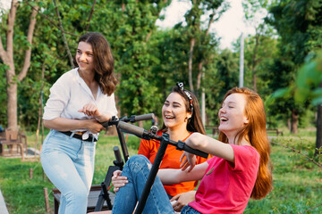 Summer activities for teens and adults. Bicycle and electric scooter rentals. Summer Bucket List, Fun Ideas for Adults. Young women friends riding electric scooters in city street, park.