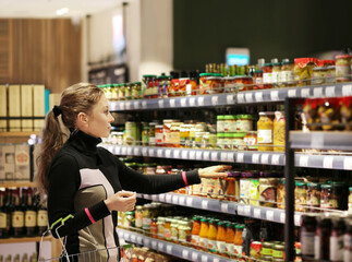Woman choosing frozen food from a supermarket freezer.choosing a dairy products at supermarket.