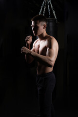 Fototapeta na wymiar The bag practices athlete the blows boxer glove black young male competition, from strength muscle from fight and fist competitive, shadow aggression. Athletic active box, fitness