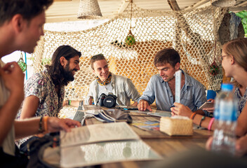 Exploring all day can really make you hungry. Shot of a group of young friends chatting while relaxing in a restaurant.