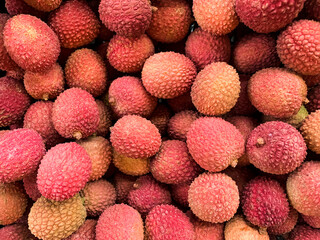 Lychee fruit background. Harvest of litchi fruits. Pink fruit. Texture. Pattern. Lychee exotic fruit background. Full frame picture of harvested litchi fruits or berries. Asian food. 