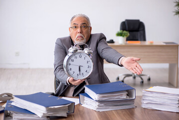 Old male employee in time management concept