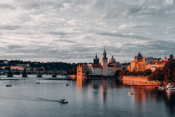 Fototapeta premium Right bank of Vltava river with Old Town Water Tower and Charles Bridge at dusk