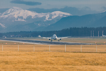 Rear view of modern twin jet engine descending from the clouds. Low flying passenger jet liner...