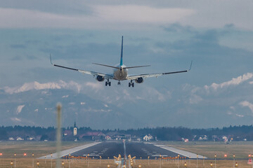 Rear view of modern twin jet engine descending from the clouds. Low flying passenger jet liner...