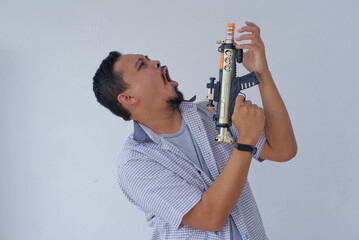 side view of man holding machine gun toy