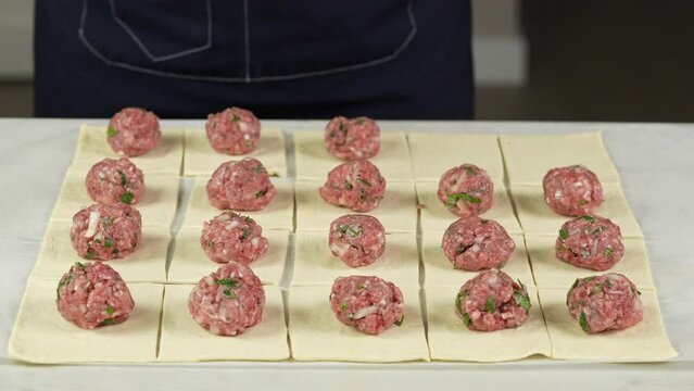 the chef forms balls of minced meat and puts on the dough. Cooking stuffed pies at home. Snacks