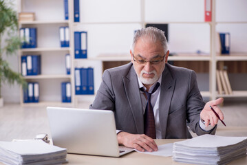 Old male employee unhappy with excessive work in the office