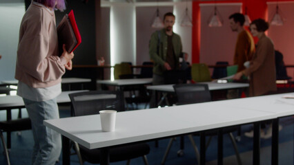 Energetic young students are coming into the classroom, greeting each other and sitting down their desk, preparing for the seminar