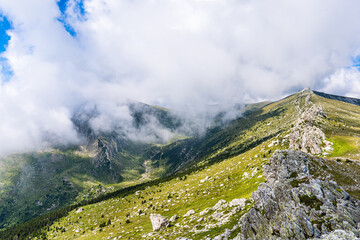 High mountain landscape with soft white clouds.