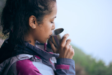 Coffee breaks are needed on early morning hikes. Cropped shot of an attractive young woman drinking coffee while taking a break during her early morning hike.