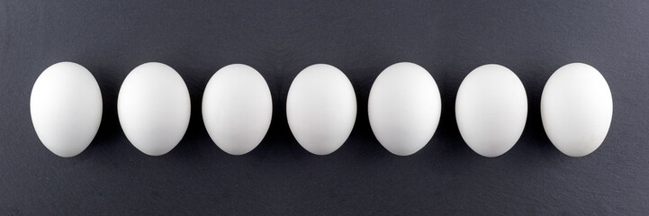 White eggs on a black stone background