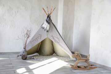grey wigwam in the nursery. wooden rocking horse toy © Vitova Ylia