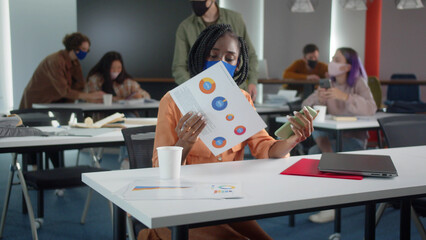 An attractive young african professor is searching through the Internet and preparing for the seminar