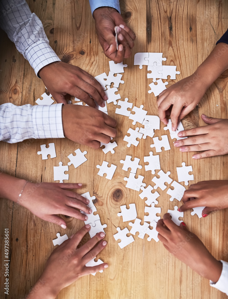 Poster this team isnt easily puzzled. high angle shot of a group of unidentifiable businesspeople building 