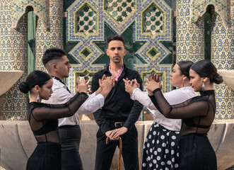 group of pupils dressed in flamenco dancing in pairs in front of their teacher looking at the camera