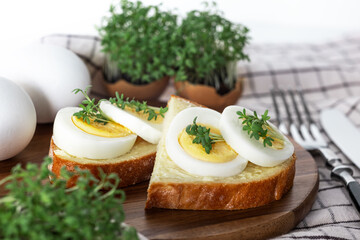 Breakfast sandwich with hard boiled eggs and micro green.