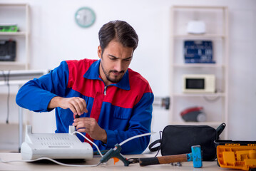 Young male repairman repairing heater