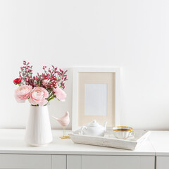 Bouquet of red and pink Persian buttercups on a white table. Scandinavian style. Place for text. Copy space
