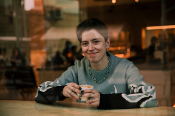 Lesbian girl drinking coffee alone sitting in a coffee shop