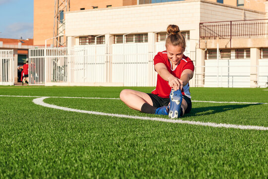 Fototapeta A woman soccer player stretches during a training session