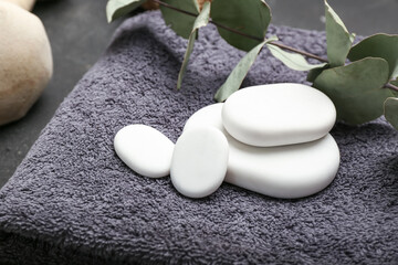 Fototapeta na wymiar Spa stones with bathing towel on dark background, closeup