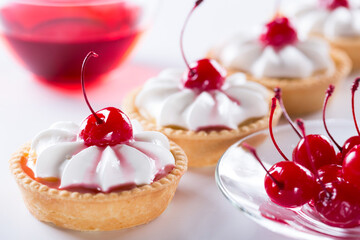Close-up of a shortbread basket with cream and cherries. Production of pastries and cakes.
