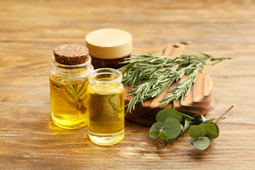 Bottles of natural essential oil on wooden background