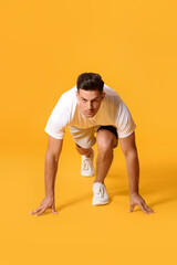 Sporty male runner on color background