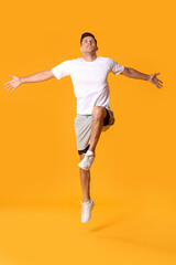 Fototapeta na wymiar Sporty jumping young man on color background