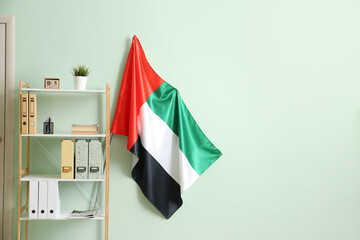 Shelf unit with UAE flag near color wall