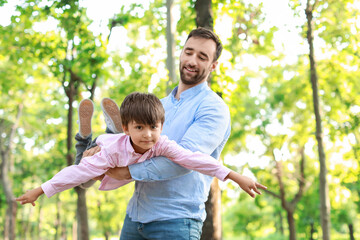 Little boy having fun with his father in park