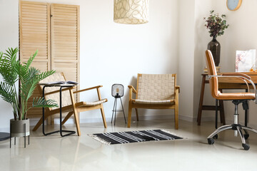 Stylish armchairs in interior of light room