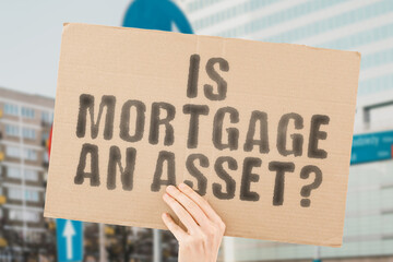 The question " Is mortgage an asset? " on a banner in men's hands with blurred background. Fund. Future. Plan. Policy. Personal. Realty. Rising. Real Estate. Rate. Trust. Buyer. Market. Sale. Bank