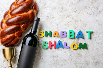 Traditional challah bread with bottle of wine and text SHABBAT SHALOM on grunge background - obrazy, fototapety, plakaty