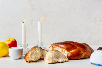 Traditional challah bread with glowing candles on light background. Shabbat Shalom