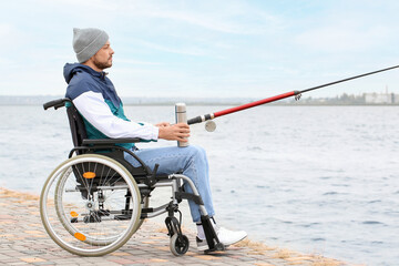 Man in wheelchair fishing on river