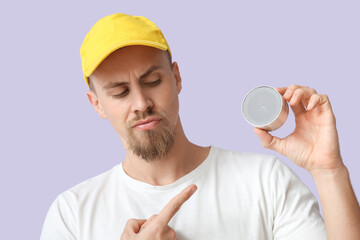 Man pointing at wireless portable speaker on violet background