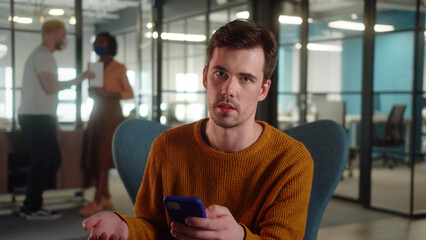 A young man-student sits on the chair and repeating her speech for performance, close up