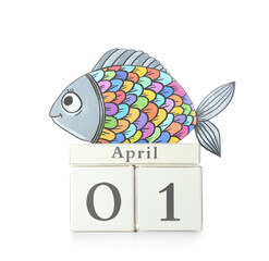 Cube calendar and paper fish on white background. April Fools Day celebration