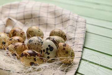 Fresh quail eggs on green wooden background, closeup